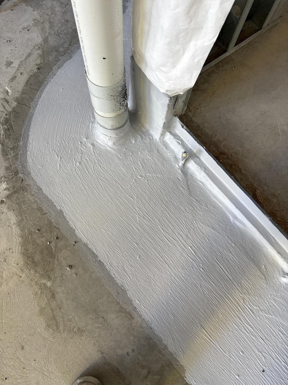 Membrane detailing sealed around pipe penetrations on a set down slab