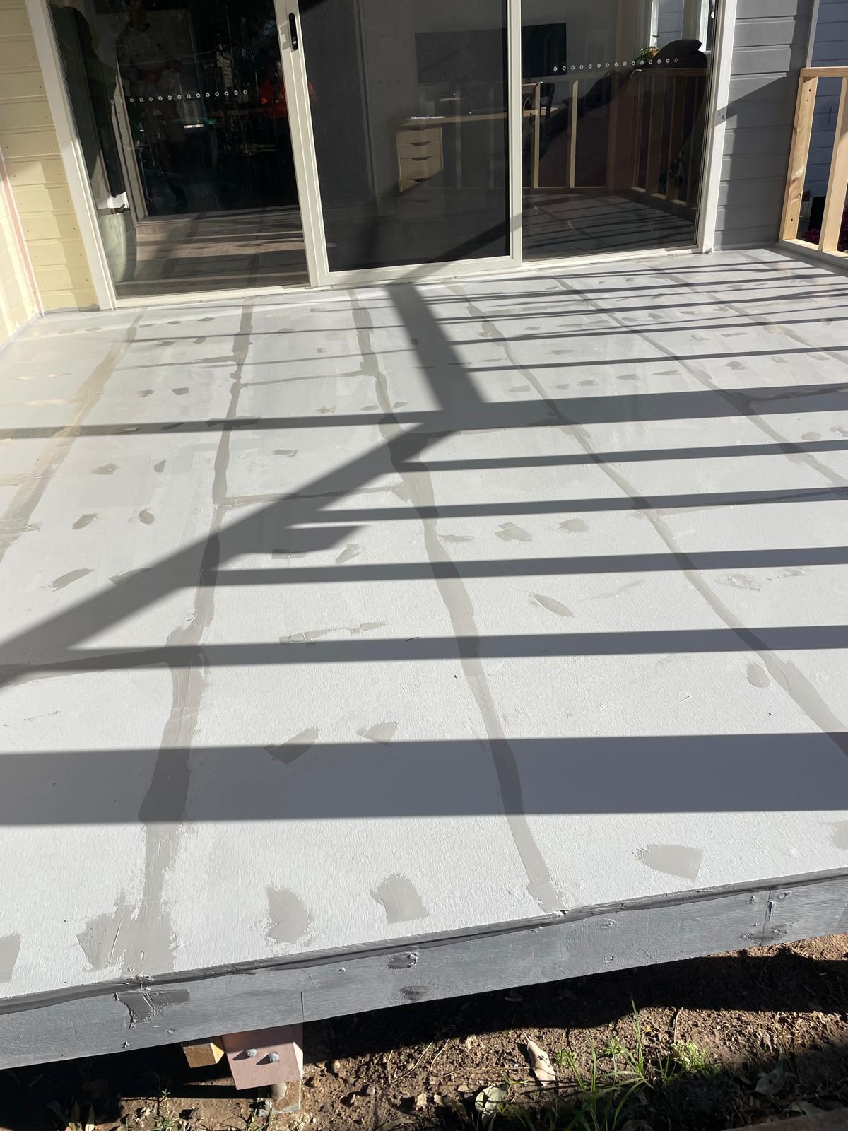 Large balcony deck fully coated in white waterproofing membrane over sheeting joints
