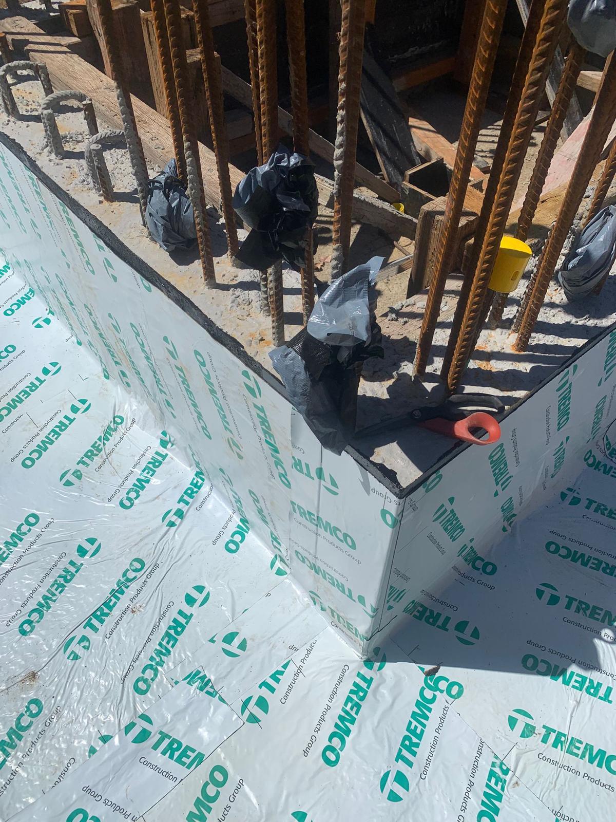 Basement wall wrapped in Tremco sheet tanking membrane with taped joints