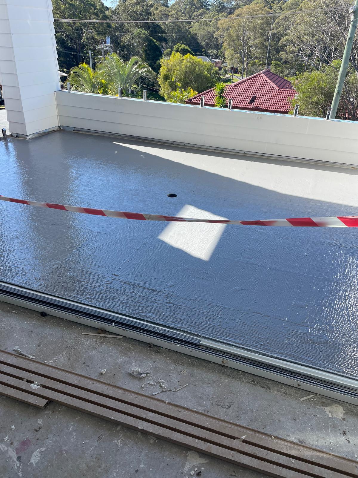 Balcony threshold and deck sealed with grey membrane at the sliding door track