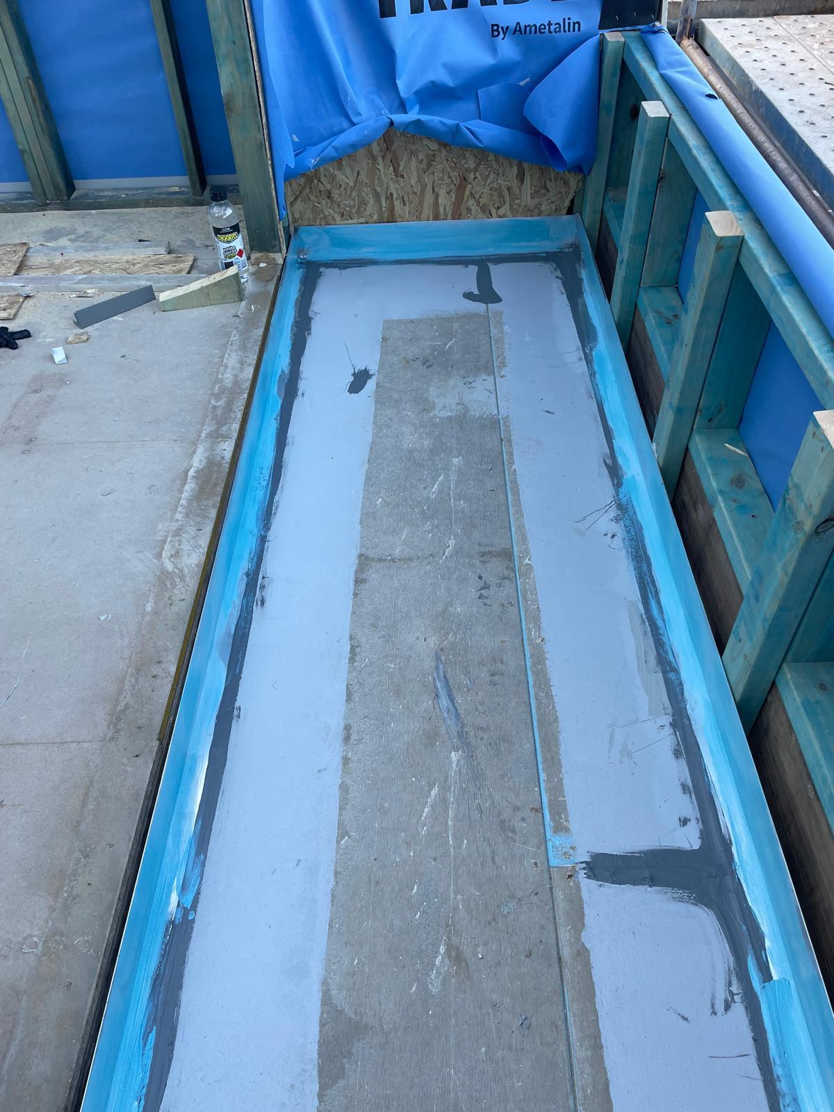 Balcony set down sealed with blue and grey membrane bands before tiling